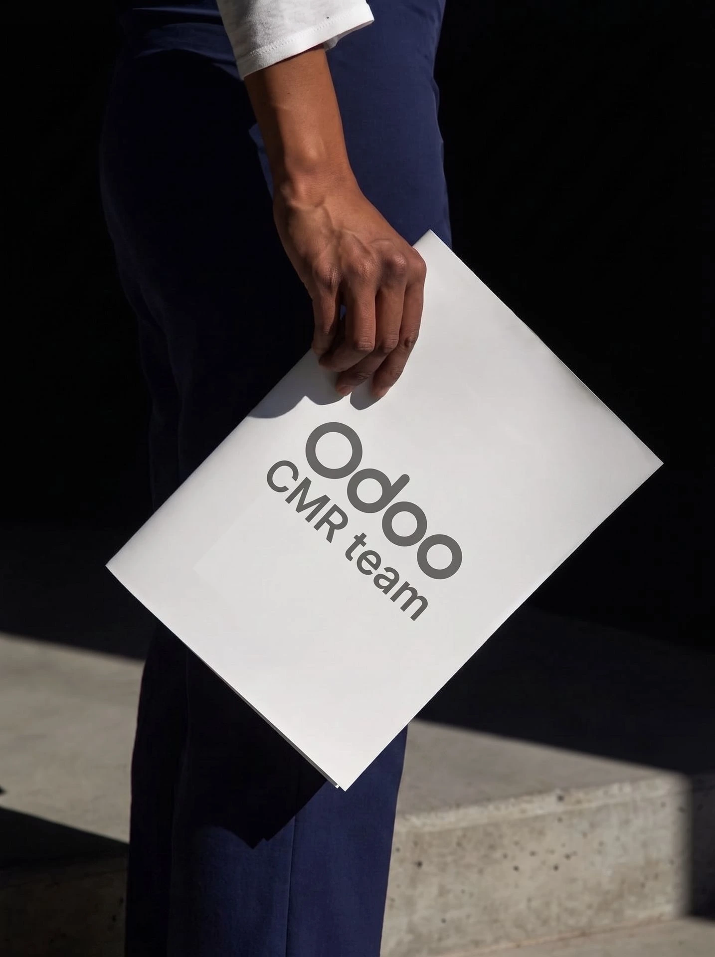 Persona sosteniendo una carpeta de trabajo de Odoo CRM team de Newconomie