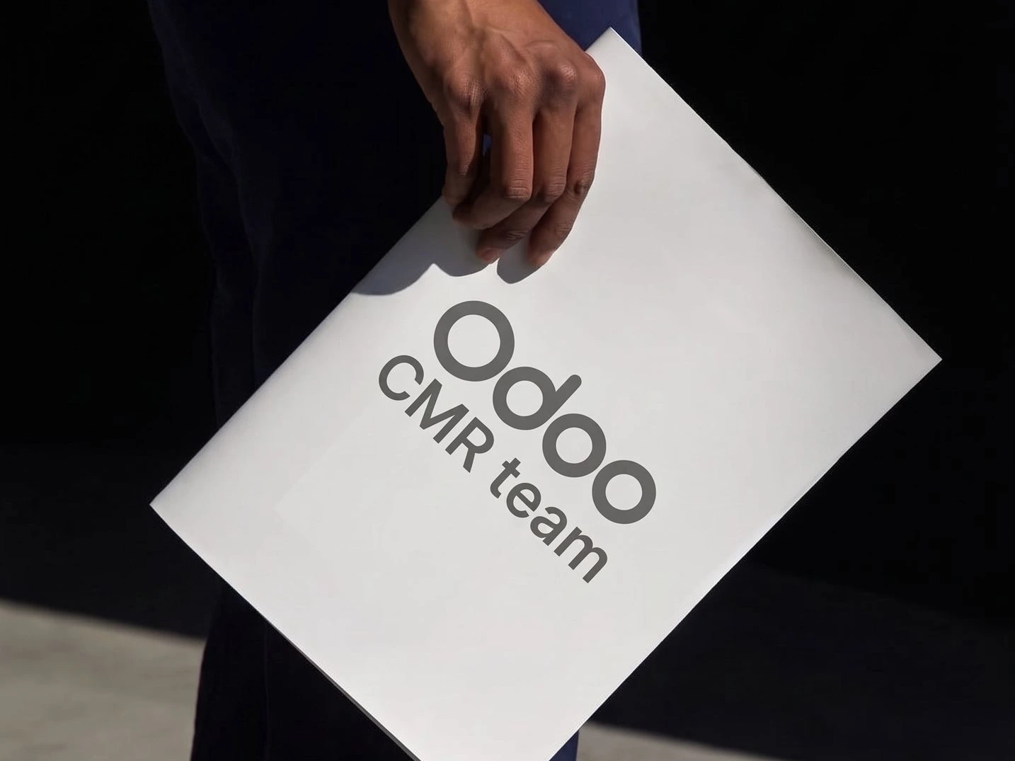 Persona sosteniendo una carpeta de trabajo de Odoo CRM team de Newconomie